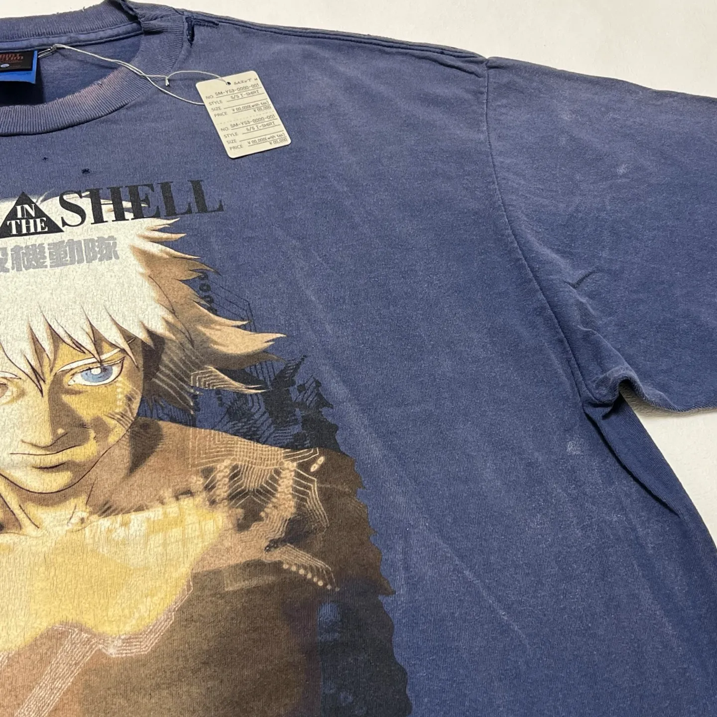 SAINT Mxxxxxx × Ghost in the Shell GS_SS TEE/GST IN THE SHELL/NVY Ghost in the Shell co-branded distressed short-sleeves White-haired plain character TEE Washed blue S-XL Look for the cylindrical fabric with no side seams. The open width is almost meaningless Asut ready-made garments dyed The whole piece is sprayed with horsetail. The collar and cuffs are faded. The collar and cuffs are frayed. Many hangings are worn. The oversized printing position restores the authenticity level. Customized joint main mark/wash mark/with little angel anti-counterfeiting mark